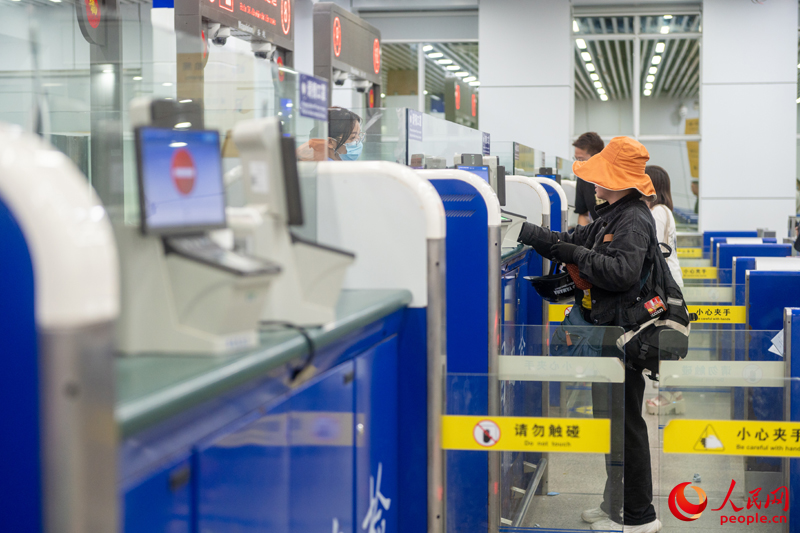 越南游客正在辦理入境手續(xù)。人民網(wǎng)記者 嚴(yán)立政攝