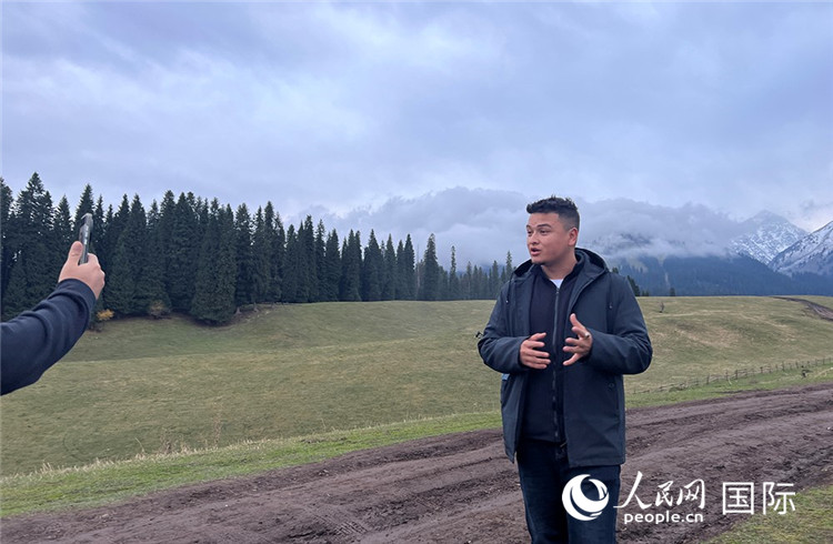 在庫爾德寧，吾買爾江被雪山美景震撼，即興錄制了短視頻作品。人民網(wǎng)記者曾書柔攝