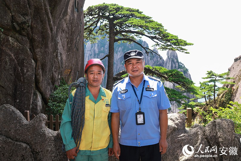 全國(guó)道德模范李培生（左）和胡曉春在迎客松前合影。人民網(wǎng)記者 張俊攝
