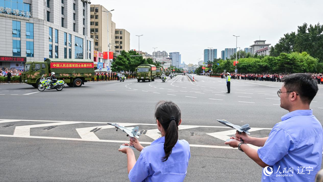 航空工業(yè)沈飛的青年技術(shù)人員拿著受閱戰(zhàn)機的模型迎接烈士遺骸。航空工業(yè)沈飛供圖