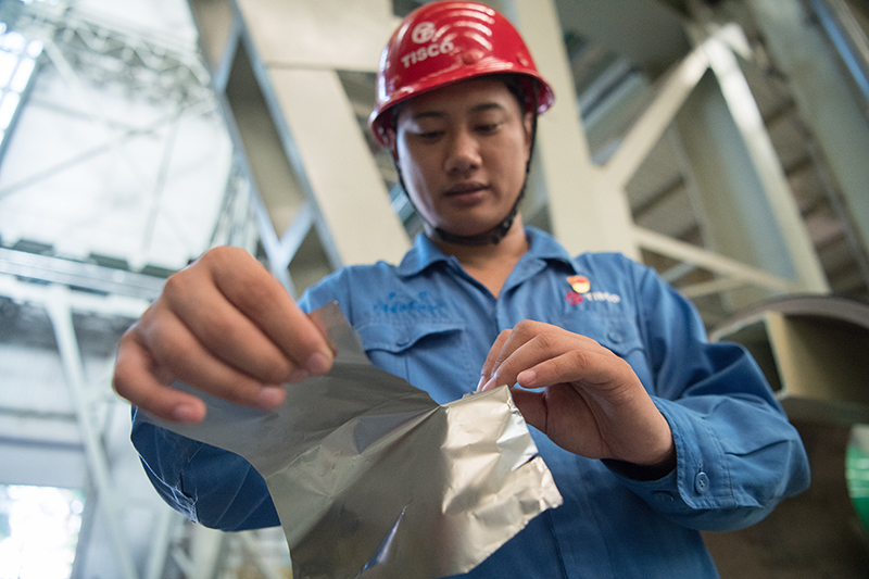 2018年8月8日，山西省太原市，太鋼精密帶鋼公司工作人員用手撕開不銹鋼。