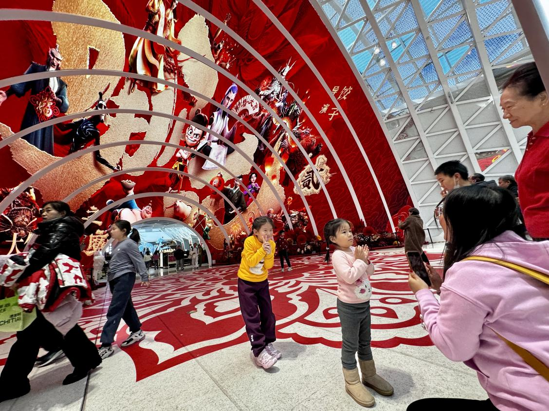 乙巳蛇年春節(jié)期間，影迷在《哪吒之魔童鬧海》巨幅海報前拍照打卡。