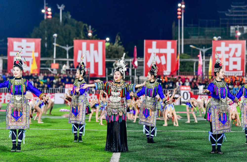 2025年3月14日，2025年貴州“村超”40強交叉賽在榕江“村超”足球場舉行，演員在比賽間隙表演侗族大歌，民族文化伴隨著體育賽事成功“出圈”。圖片來源：新華社