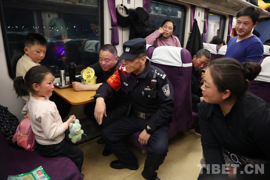 乘警長左紅彬在巡視車廂間隙，向攜帶兒童的旅客專門叮囑安全注意事項。.JPG