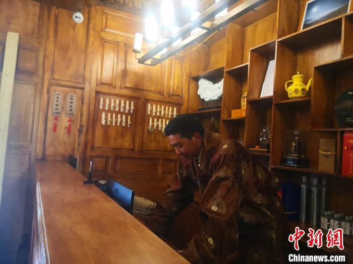 圖為桑杰才讓用電腦處理財(cái)務(wù)。　史靜靜 攝