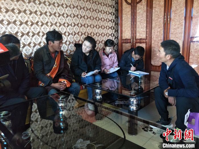 圖為調(diào)查組工作人員正在入戶調(diào)查?！∑钤鲚?攝