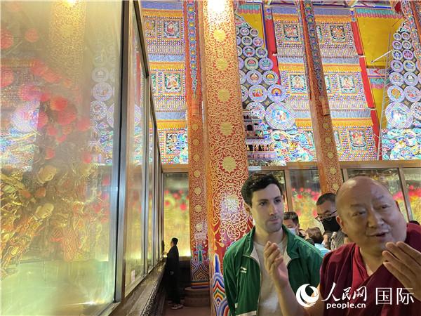 7月25日，省級非物質(zhì)文化遺產(chǎn)項目塔爾寺酥油花的代表性傳承人朋措堅參（右）在塔爾寺酥油花館講解酥油花的制作過程。人民網(wǎng) 謝瑩攝