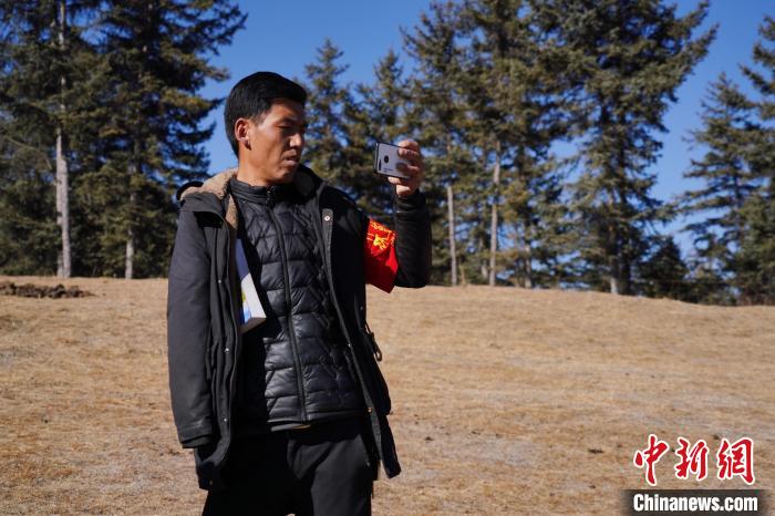 圖為桑杰加進(jìn)行巡查并拍照記錄?！●R銘言 攝