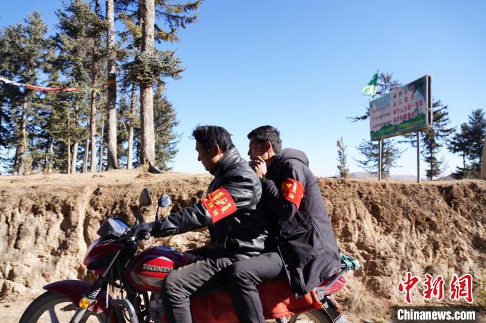 圖為同事騎摩托車載著桑杰加(后)前往林場(chǎng)?！●R銘言 攝