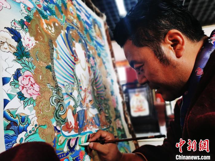 圖為久美尖措創(chuàng)作唐卡。　張?zhí)砀?攝