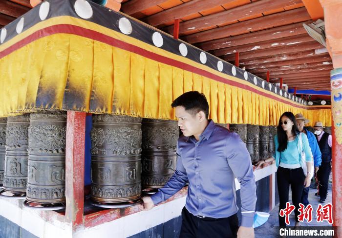 圖為外籍嘉賓體驗(yàn)藏族傳統(tǒng)轉(zhuǎn)經(jīng)筒?！●R銘言 攝