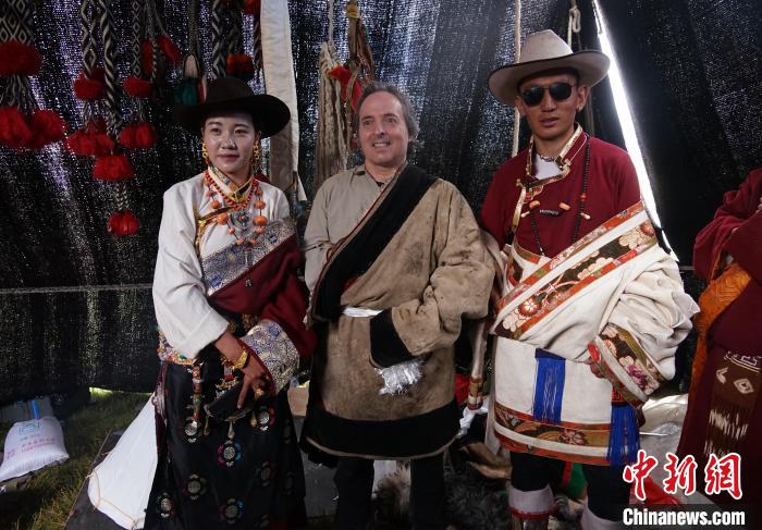 圖為一名外籍?dāng)z影師(中)身穿藏服和藏族民眾合影留念?！●R銘言 攝