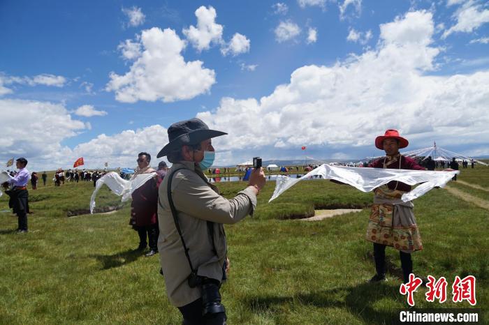 圖為一名外籍?dāng)z影師記錄當(dāng)?shù)夭刈鍤g迎儀式?！●R銘言 攝