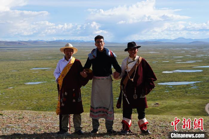 圖為一名留學(xué)生身穿自己國家的服飾和藏族民眾合影留念?！●R銘言 攝