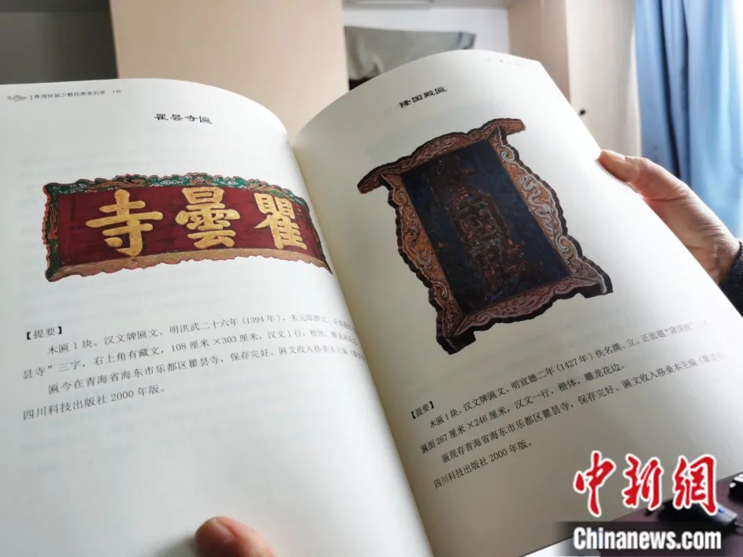 古籍保護人員展示介紹明代朱元璋撰寫的青海瞿曇寺匾(左)的出版書籍。張?zhí)砀?攝