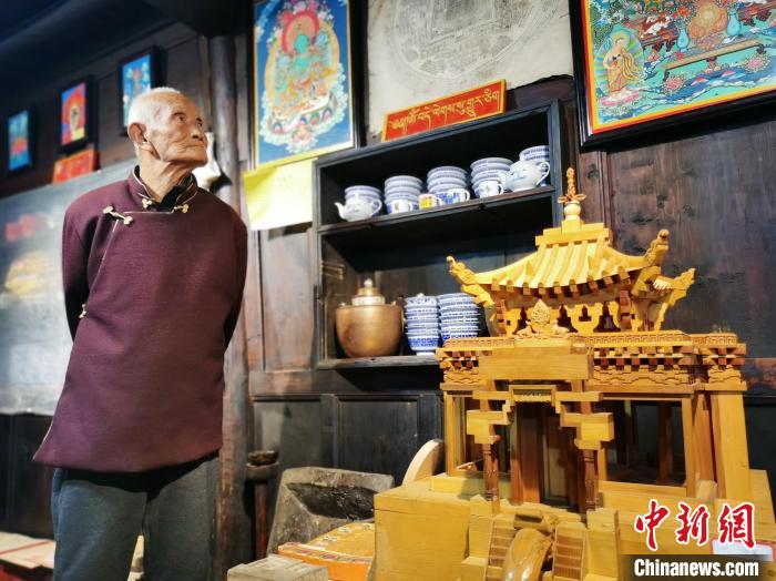 圖為古堡內(nèi)的藝人桑杰展示自己的雕刻作品?！?zhí)砀?攝