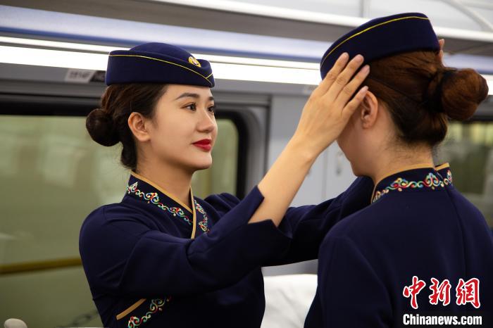 圖為青藏鐵路西格段“復興號”動車組乘務員互相整理新制服?！±罾?攝