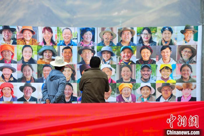 圖為當(dāng)?shù)孛癖娫谟^看展板上的笑臉?！垈?攝