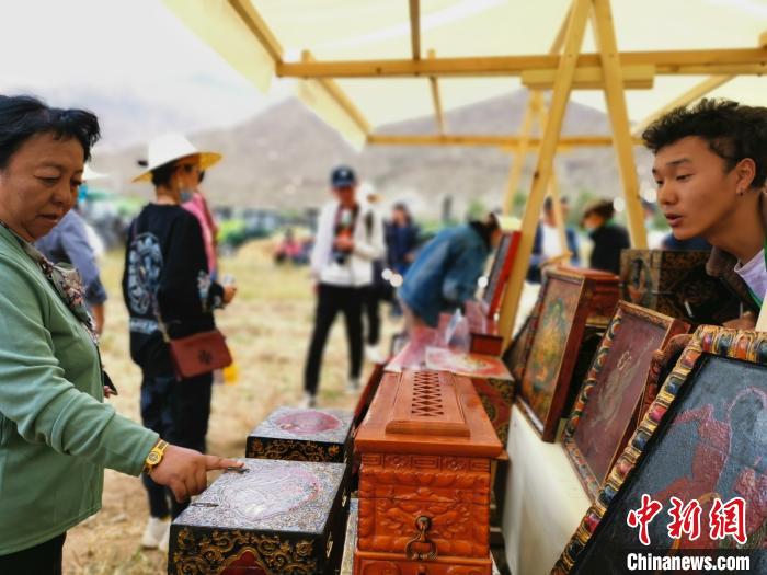 圖為拉薩市民在特色農(nóng)畜產(chǎn)品展示展銷會(huì)上選購(gòu)商品?！垈?攝