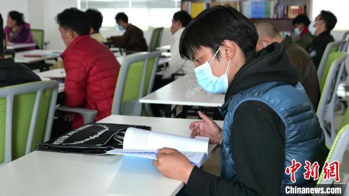 圖為正在閱讀“杰松達(dá)孜”藏歷法教材的學(xué)員。　謝牧 攝