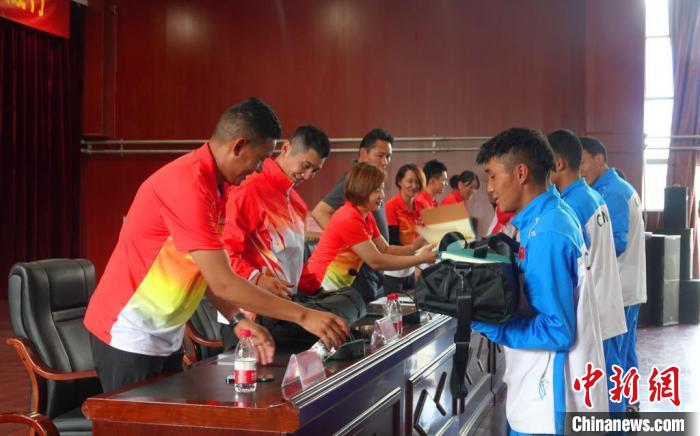 圖為世界冠軍們?yōu)槲鞑刈灾螀^(qū)體校的學(xué)生們送上暖心物資。　冉文娟 攝