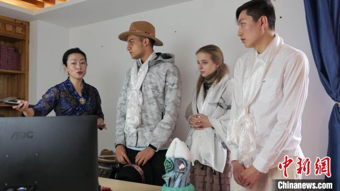 圖為圖為主播白瑪旺姆為留學生介紹直播流程?！≈x牧 攝