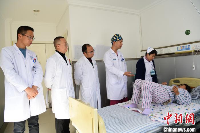 圖為何蔚副主任醫(yī)師(站右二)及團隊術(shù)后指導(dǎo)患者進行腰背肌鍛煉。　貢嘎來松 攝