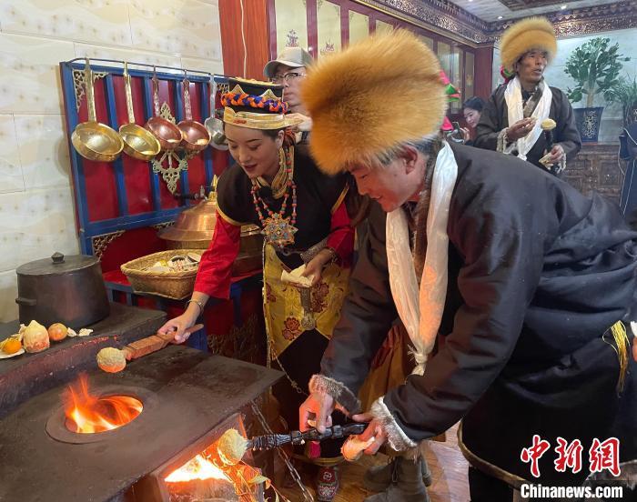 圖為人們在火上烤節(jié)日美食“結(jié)達(dá)”。　冉文娟 攝