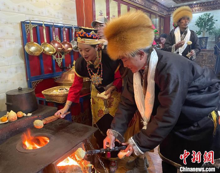 圖為人們在火上烤節(jié)日美食“結達”?！∪轿木?攝