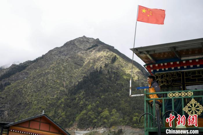 村民站在樓房上觀望?！钊A峰 攝