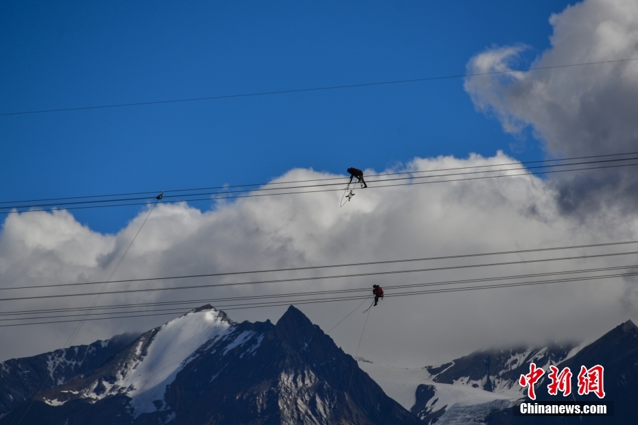 資料圖為2020年6月23日，西藏阿里聯(lián)網(wǎng)工程施工人員在日喀則希夏邦馬雪山附近進(jìn)行走線作業(yè)，安裝絕緣設(shè)備。 <a target='_blank' href='/'><p  align=