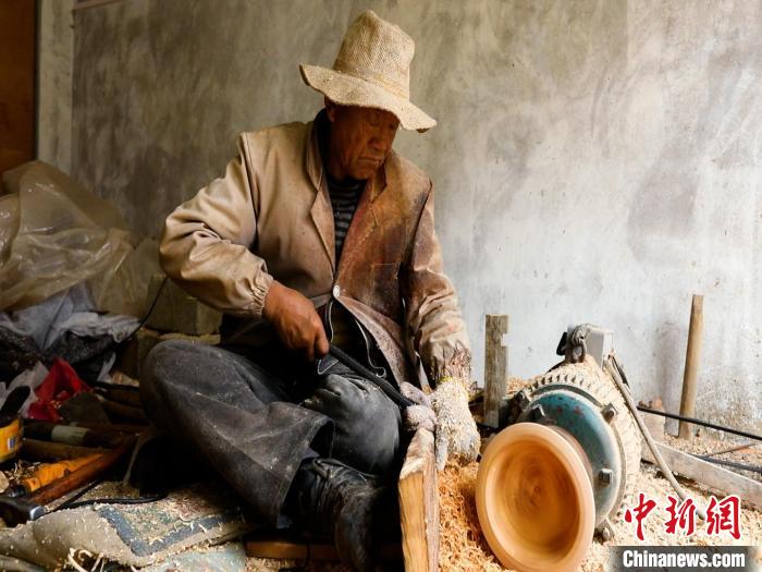 圖為手工藝人正在制作木碗。　 鄧海平 攝