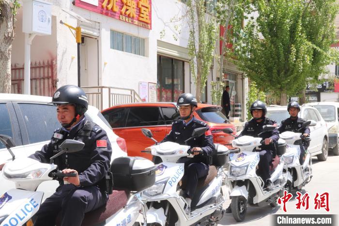 民警騎著電瓶車在轄區(qū)巡邏走訪?！↑S創(chuàng)偉 攝