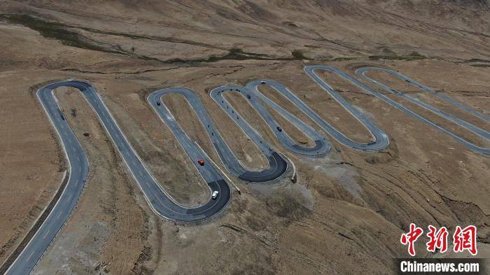 圖為騎手前往珠峰大本營途經(jīng)108道拐?！∮文恋厍蚬﹫D