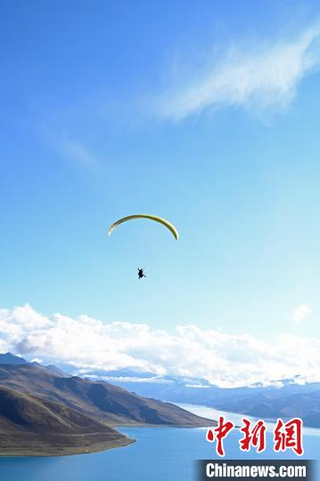 圖為在羊卓雍錯(cuò)，游客體驗(yàn)高空滑翔?！≮w朗 攝