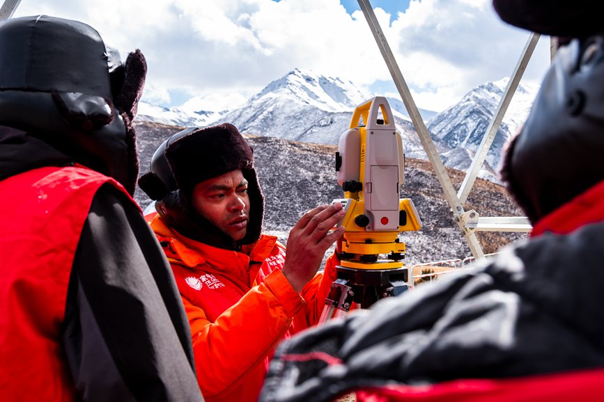 2023年11月30日，西藏自治區(qū)那曲市索縣榮布至丁青縣巴達(dá)35千伏線路工程負(fù)責(zé)人黃小洪（左二）現(xiàn)場(chǎng)開(kāi)展線路弧測(cè)量教學(xué)。趙清鵬攝