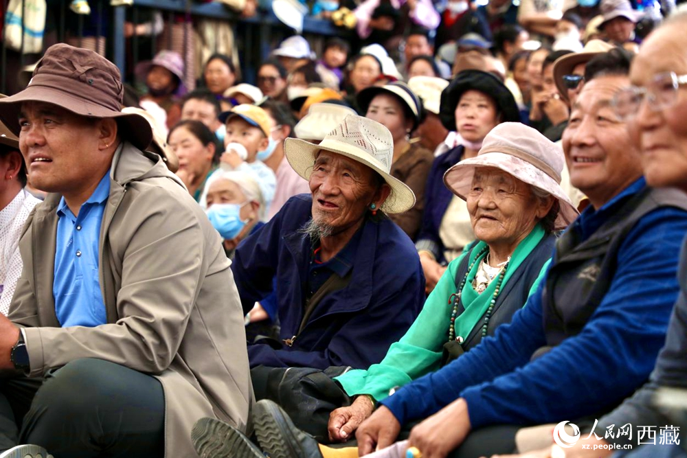 當(dāng)?shù)厝罕姾陀慰陀^看藏戲演出。