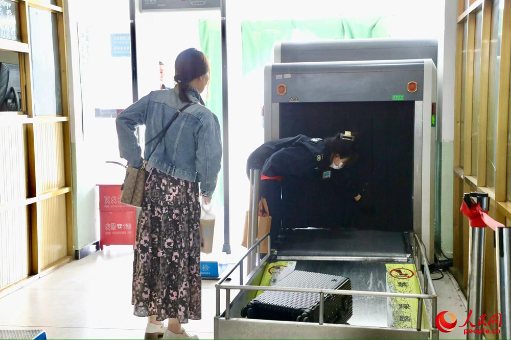 車站工作人員幫旅客提取行李。人民網(wǎng)記者 次仁羅布攝