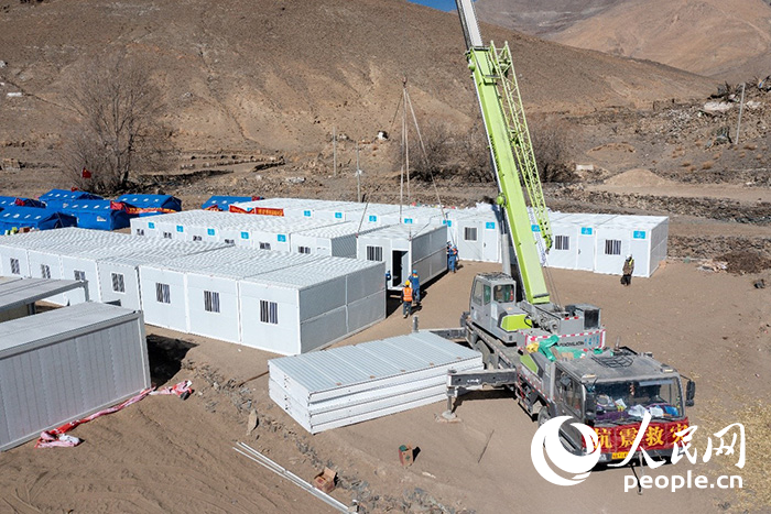 1月9日，在日喀則市定日縣長所鄉(xiāng)古榮村安置點，救援人員和施工人員合力抓緊搭建移動板房，確保受災(zāi)群眾溫暖過冬。人民網(wǎng)記者 翁奇羽攝