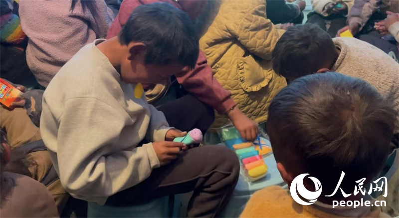 措果鄉(xiāng)塘仁村的孩子們正在用橡皮泥制作自己的情緒“小怪獸”。人民網(wǎng)記者 郝潔攝