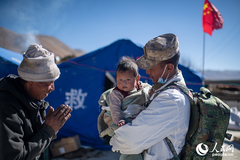 1月9日，在定日縣長所鄉(xiāng)古榮村安置點(diǎn)，受災(zāi)群眾感謝西藏軍區(qū)陸軍某部隊(duì)衛(wèi)生員的醫(yī)療救治。人民網(wǎng)記者 翁奇羽攝