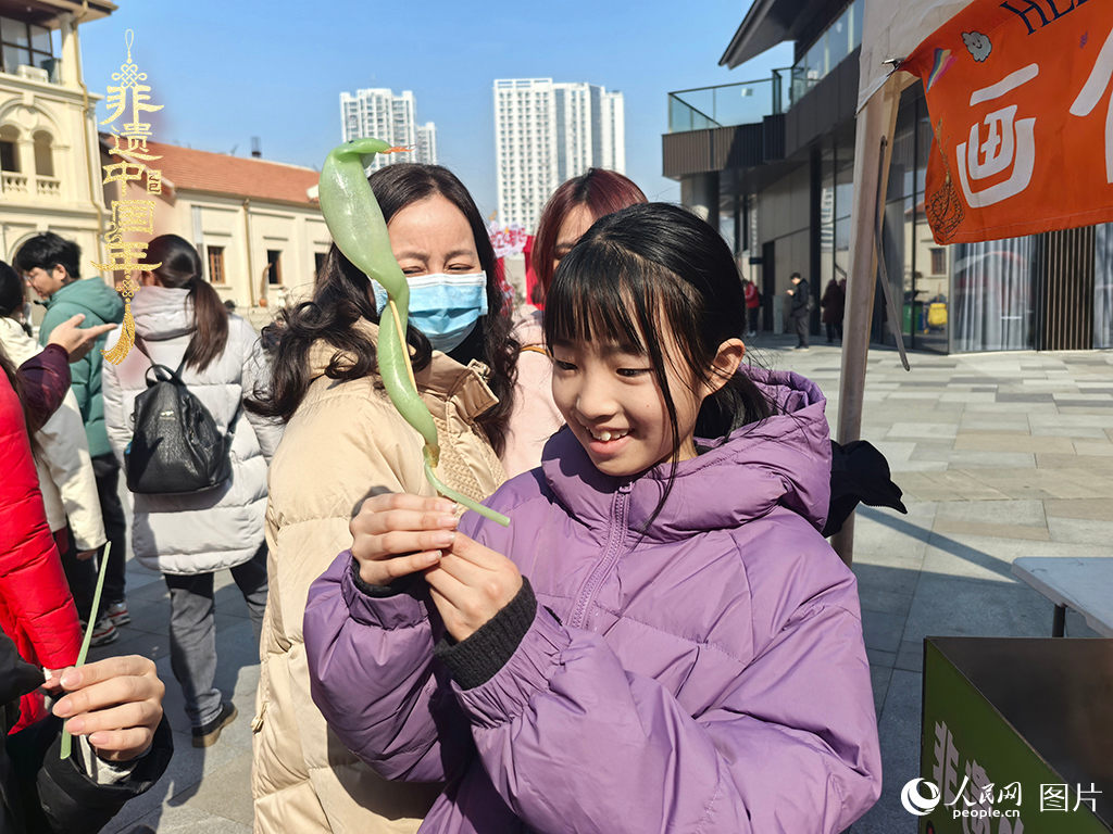 2025年1月29日，湖北武漢的新春廟會上，小朋友拿著吹制好的糖人，十分開心。人民網(wǎng)記者 張沛攝