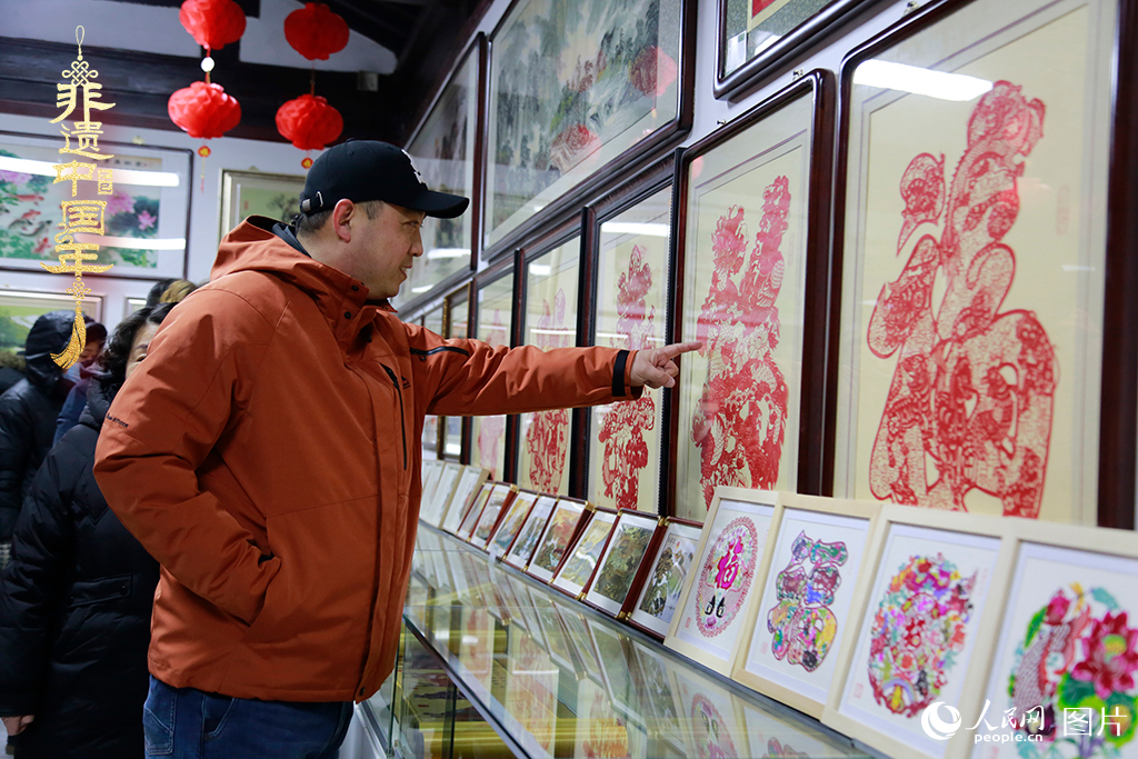 2025年1月23日，游客在天津楊柳青古鎮(zhèn)欣賞傳統(tǒng)剪紙作品，感受指尖上的古老藝術(shù)。人民網(wǎng)記者 崔新耀攝