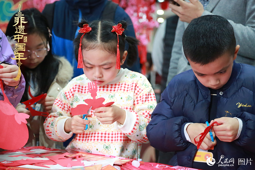 2025年1月23日，上海市青少年活動中心迎新春游園會上，小朋友們正在學習剪窗花。人民網(wǎng)記者 龔莎攝